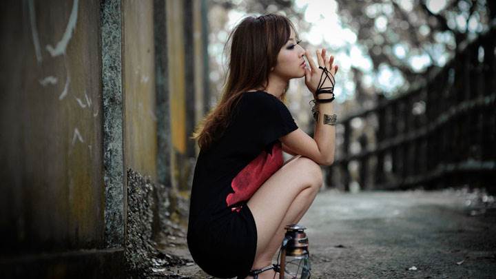 Lonely Girl Sitting With A Lamp And Thinking Something